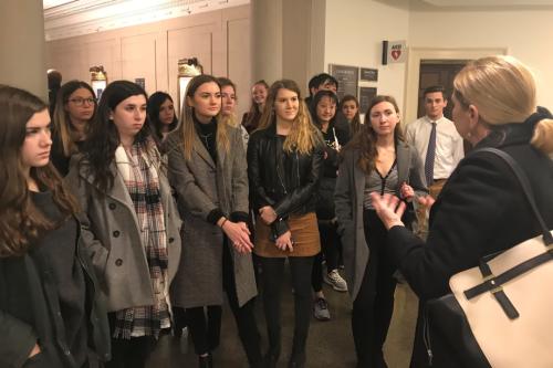 Students with a professor standing and listening to a lecture