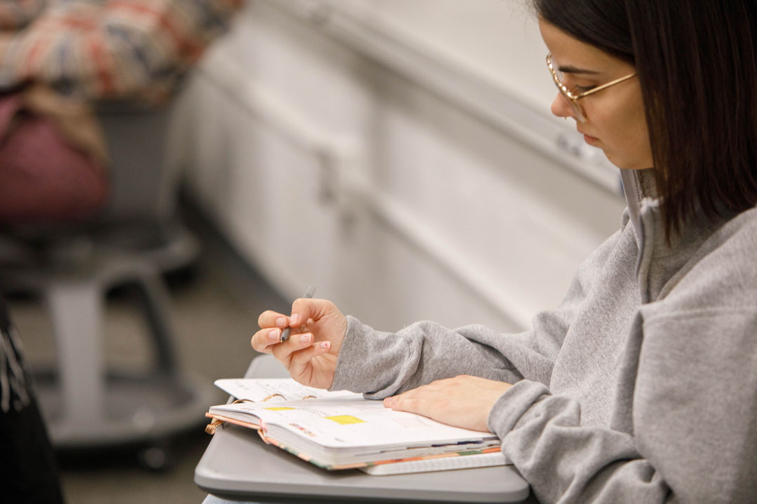 A student in a psych class writing notes